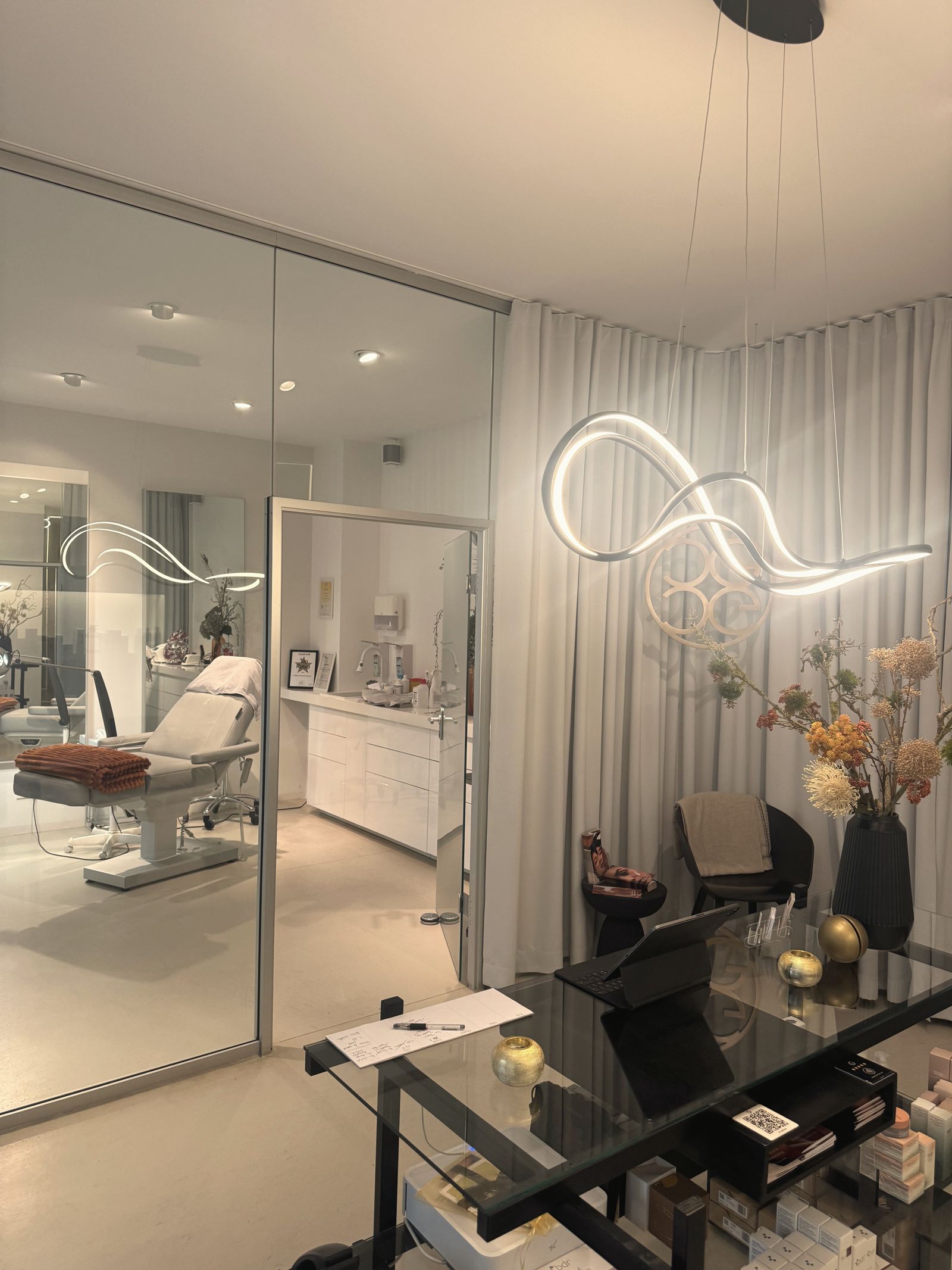 Blick durch die Glaswand in den Behandlungsraum des Ateliers Doreen bei CAPEGOLD Berlin